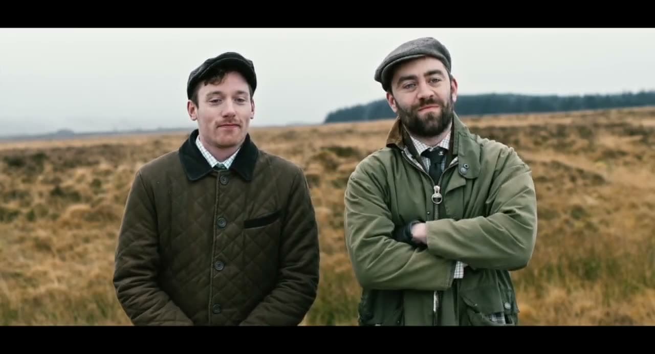 Christopher Adams and another actor in flat caps and waxed jackets on a moor